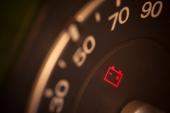 Close up shot of a car's dashboard with the battery icon lit. 510062080