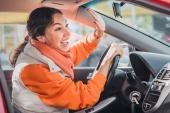 Polite woman driver raised her hand as a sign of respect and says thank you for giving way. Relations between people in traffic regulations