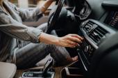 Car dashboard. Radio closeup. Woman sets up radio